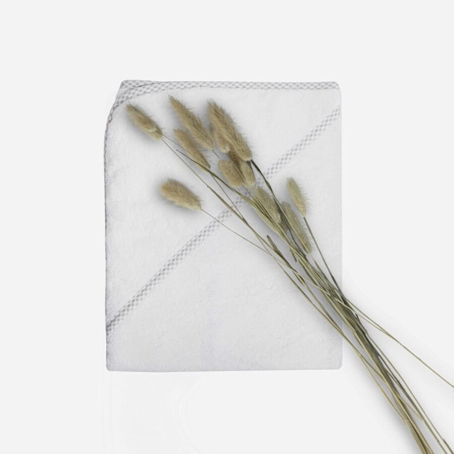 Sortie de bain pliée pour bébé en éponge blanche avec liseré vichy gris et fleurs de pampa collection le petit bambou