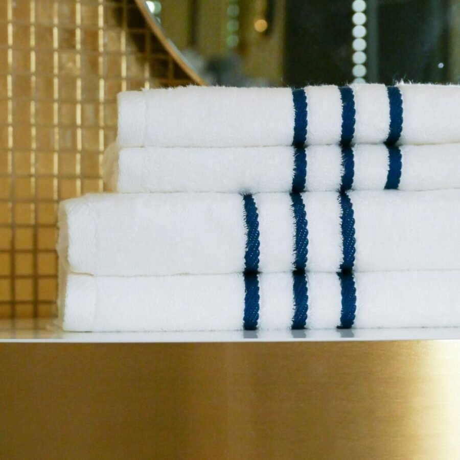 Image détaillée de serviettes en bambou finement pliées, déposées sur une table, créant une ambiance accueillante et luxueuse dans cet espace.