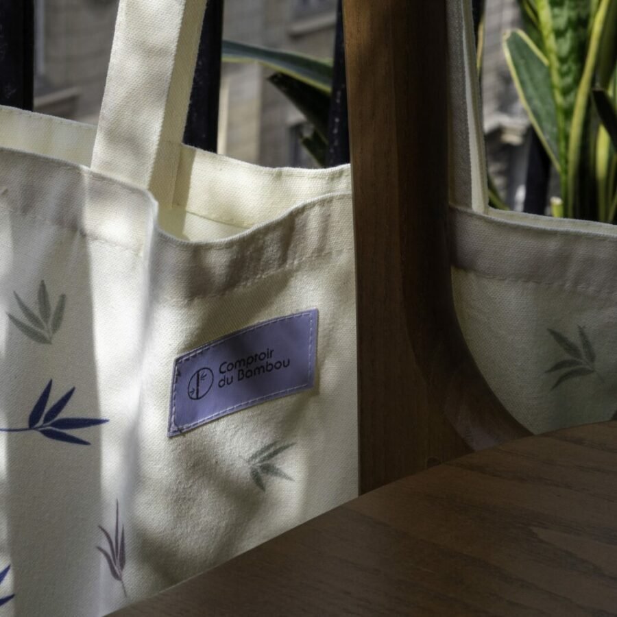 Un tote bag élégamment présenté avec une variété d'accessoires soigneusement disposés à l'intérieur, prêt à vous accompagner lors de vos aventures quotidiennes. Des lunettes de soleil, une bouteille d'eau, un carnet et un porte-monnaie se nichent confortablement dans le sac, offrant à la fois praticité et style pour une journée bien remplie à l'extérieur. Ce tote bag polyvalent est l'accessoire parfait pour toutes vos escapades, qu'elles soient en ville, à la plage ou en voyage.