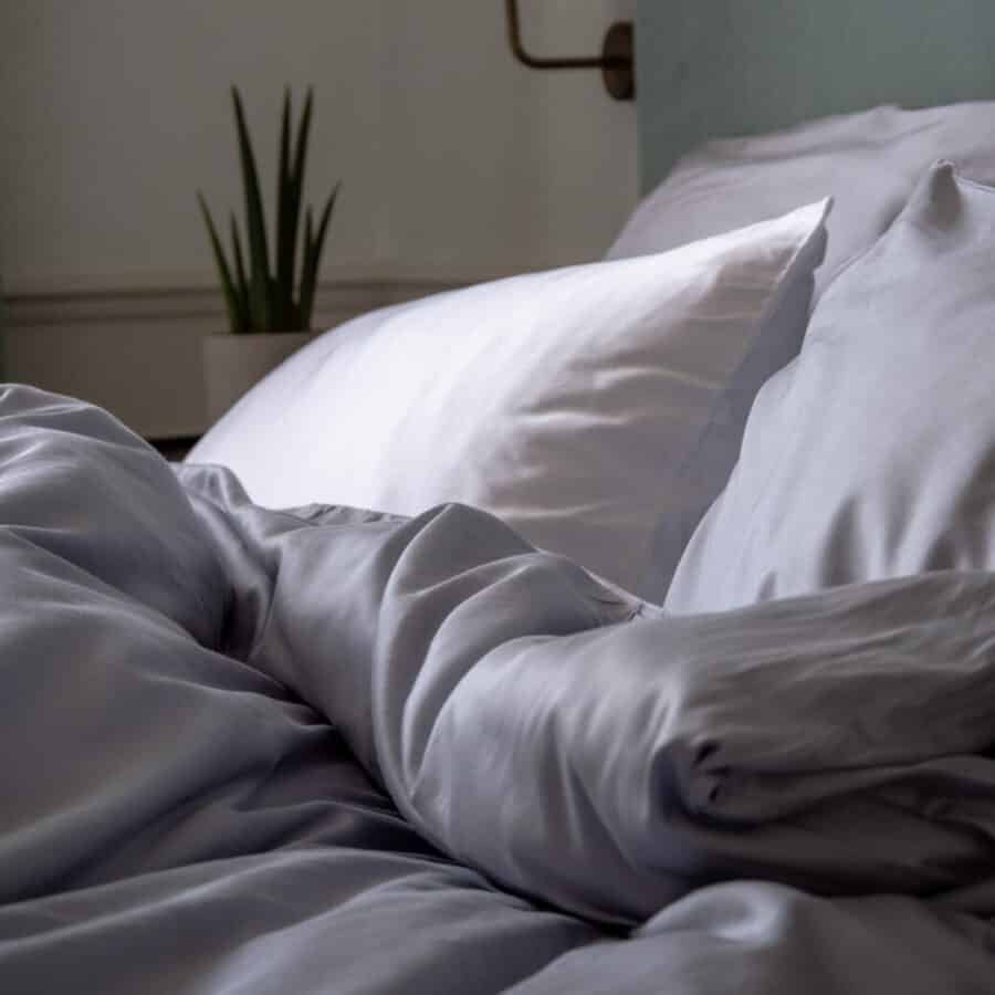 Chambre d'hôtel élégante avec un lit king-size habillé de draps en fibre de bambou, offrant une douceur et un luxe incomparables. Le linge de lit haut de gamme crée une atmosphère de confort et de raffinement, idéale pour une expérience de séjour relaxante et opulente.